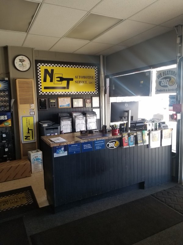 Front desk area with the NET Automotive Service sign and award plaques